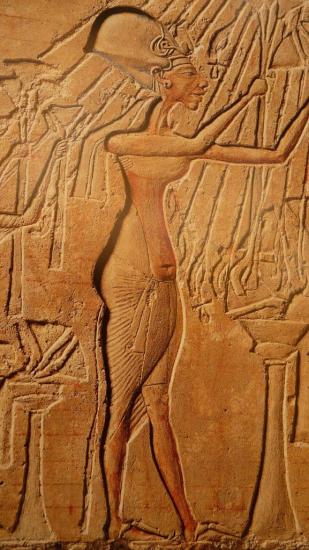 Le pagne d'Akhenaton est prolongé par une ceinture. le devanteau n'est pas plissé. Le roi porte sandales.